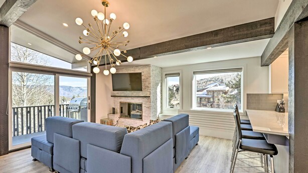 A modern living room with a sectional sofa, a fireplace, and a bar area. - Snowmass Condo: Great Proximity to Chair Lift (Snowmass Village)