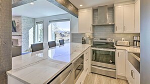 A modern kitchen with a large island, stainless steel appliances, and a view to the outside. - Snowmass Condo: Great Proximity to Chair Lift (Snowmass Village)