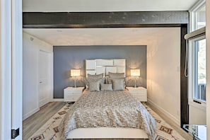Une chambre à coucher avec un lit, des tables de chevet et une fenêtre.