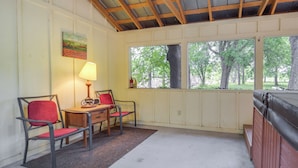 A small, enclosed room with a wooden ceiling, a window with a view of trees, two chairs, a table, and a lamp. - Studio in Fredericksburg Winery w/ Shared Hot Tub (Fredericksburg)