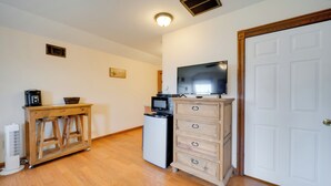 A compact kitchen with a microwave, refrigerator, wooden cabinet, and a television on a stand. - Studio in Fredericksburg Winery w/ Shared Hot Tub (Fredericksburg)