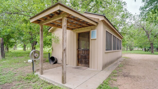 A small, single-story structure with a wooden pergola entrance, a door, and a window. - Studio in Fredericksburg Winery w/ Shared Hot Tub (Fredericksburg)
