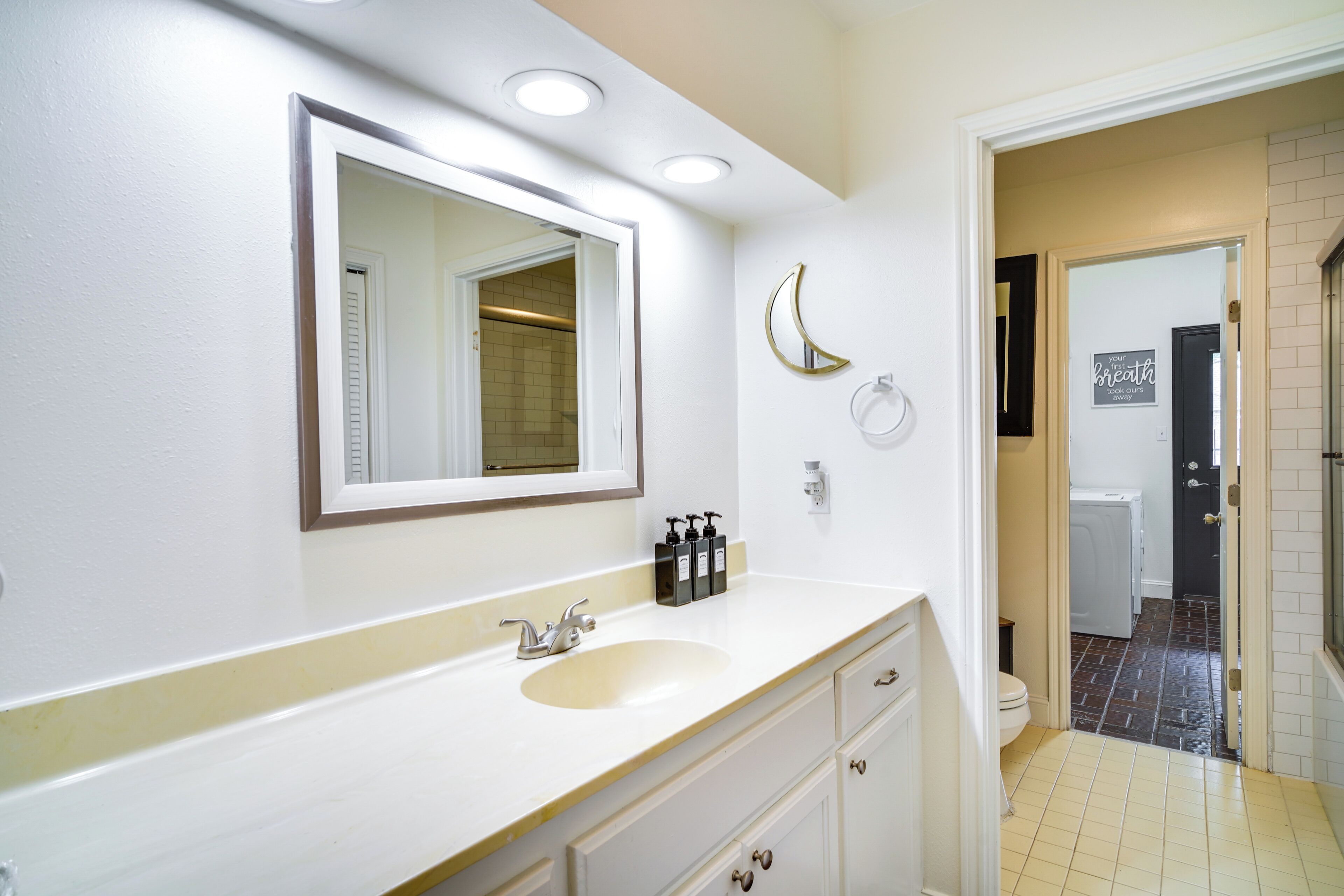 A bathroom with a white sink, mirror, and a towel rack.