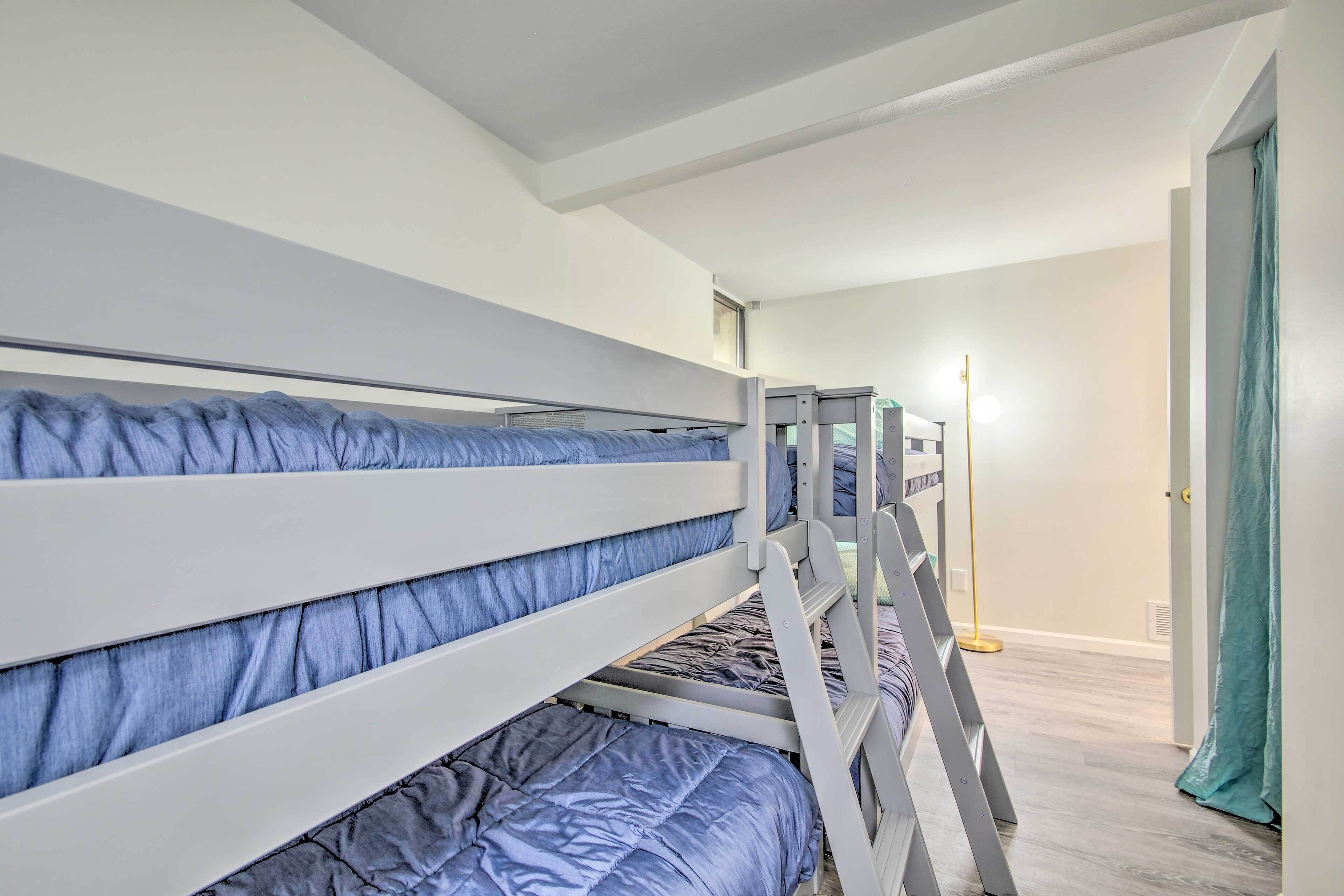 Een slaapkamer met een stapelbed, een vloerlamp en een deur met gordijn.