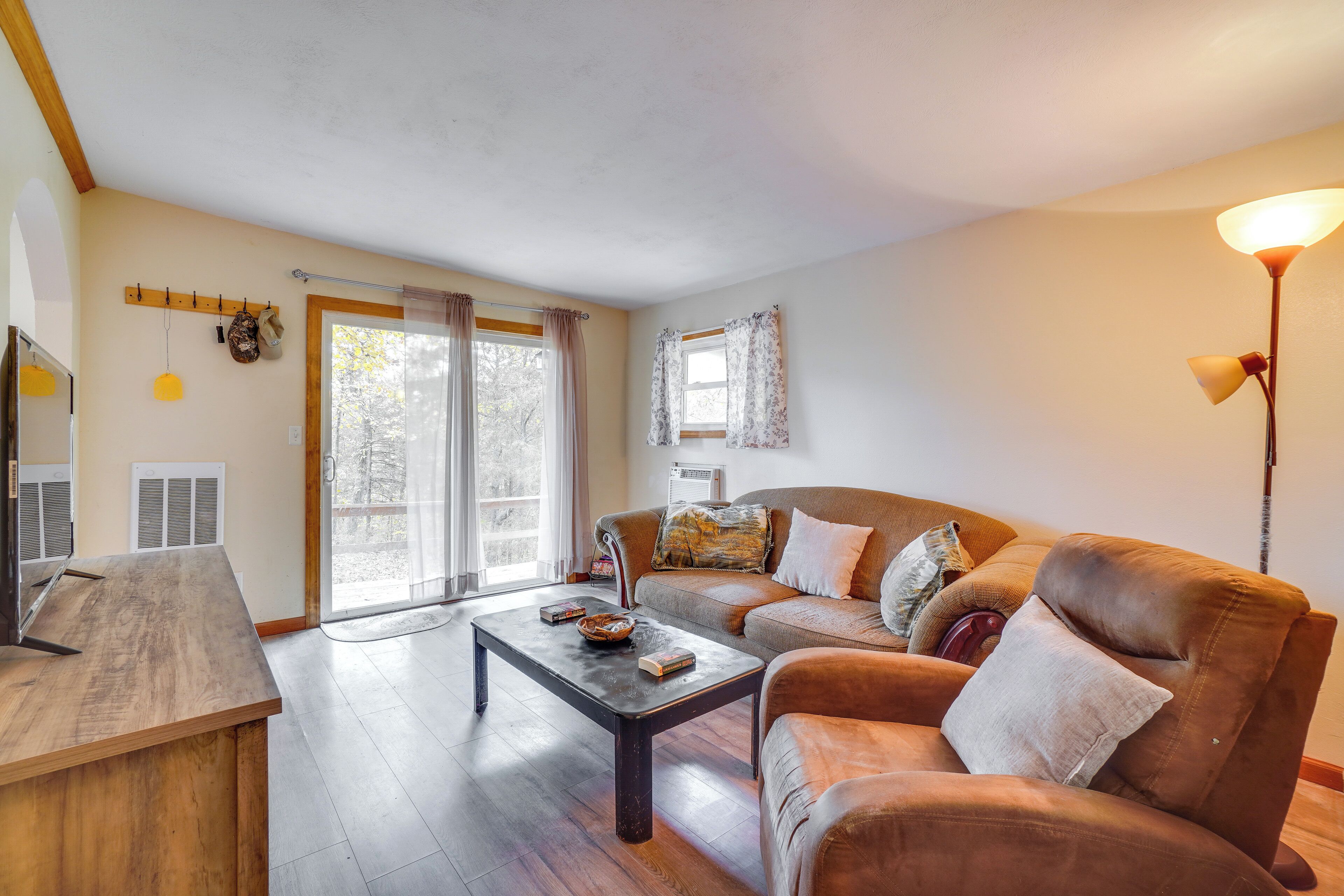 A living room with a wooden coffee table, a brown sofa, and a lamp.