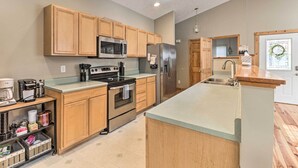 Una cocina moderna con armarios de madera, electrodomésticos de acero inoxidable y una isla grande.