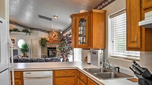 A compact kitchen with wooden cabinets, a built-in dishwasher, a stove, and a sink. - Sunny La Verkin Studio - 20 Mi to Zion Nat'l Park! (La Verkin)