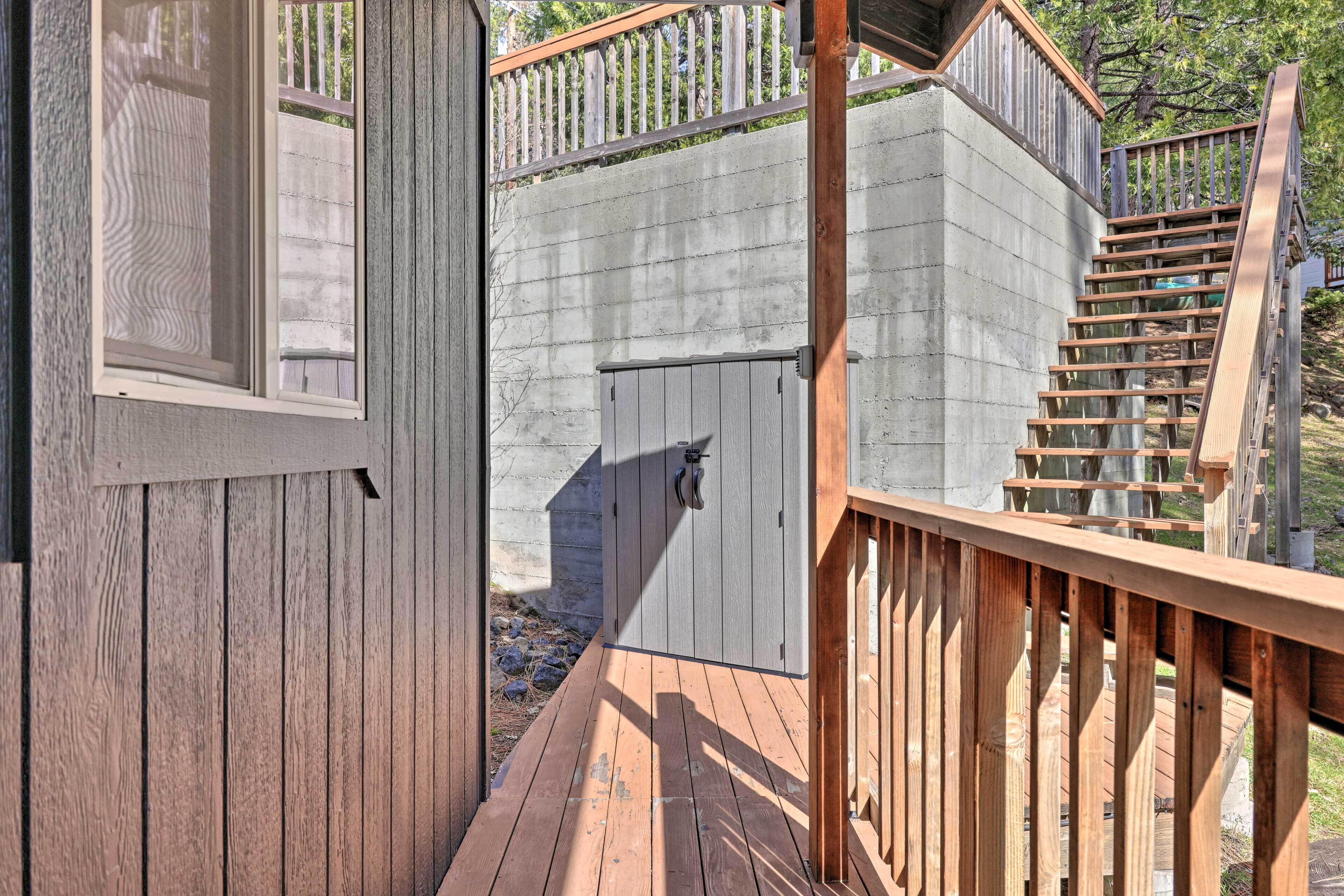 A wooden deck with a concrete wall and a metal gate.
