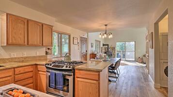 A spacious kitchen with wooden cabinets, a granite countertop, and a central island.