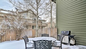 A patio with a table and chairs covered in snow, a grill, and a wooden fence. - Modern Home w/ Patio: 3 Mi to Beaver Creek Resort! (Avon)