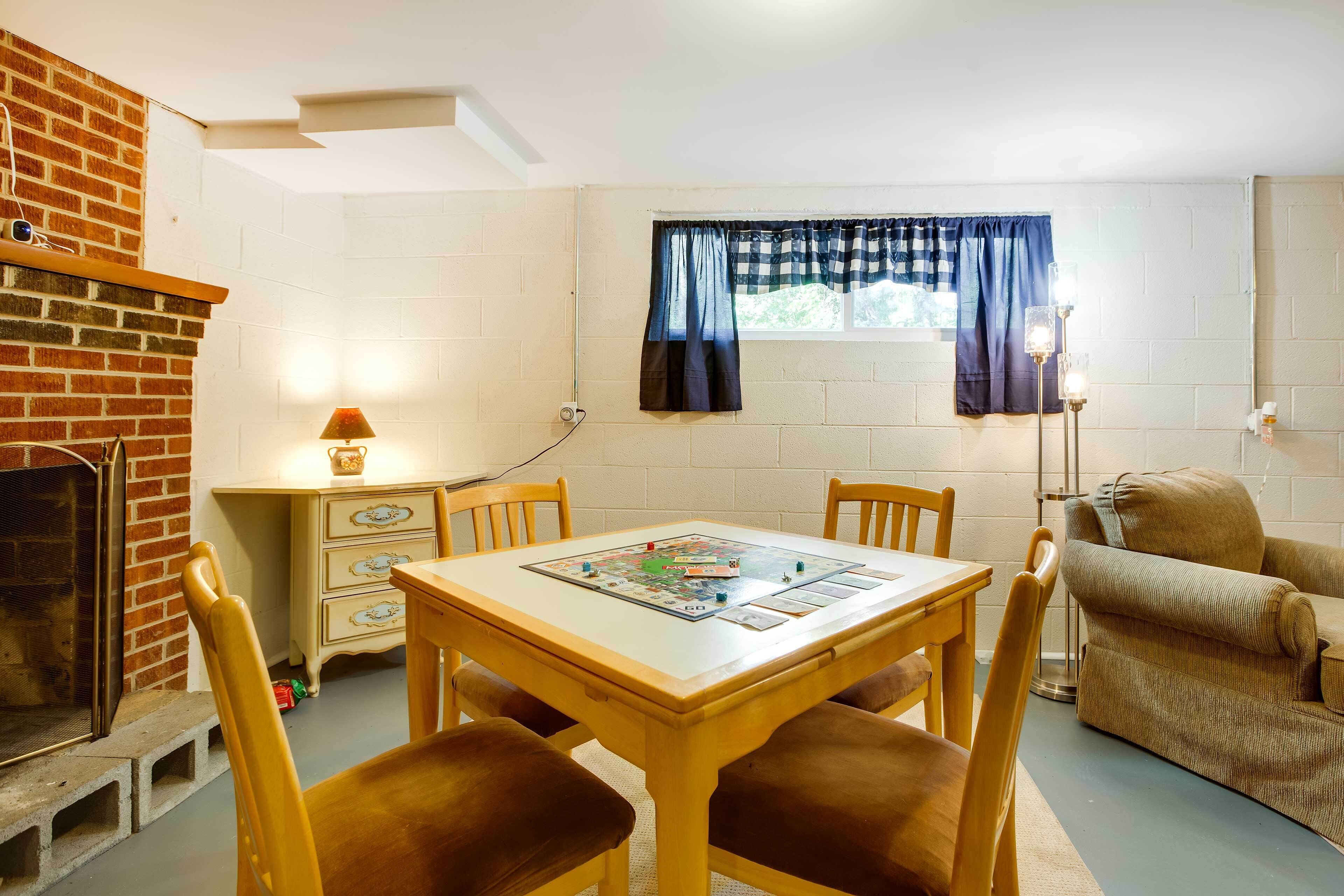 Une pièce avec une cheminée en briques, une table à manger avec des chaises, un canapé et une fenêtre avec des rideaux.