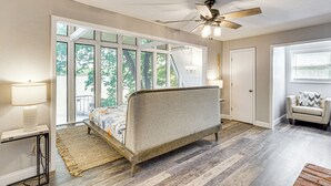 A bedroom with a bed, a ceiling fan, a window, and a nightstand. - Beach + Dock! Lakefront Ozarks A-frame Retreat (Linn Creek)