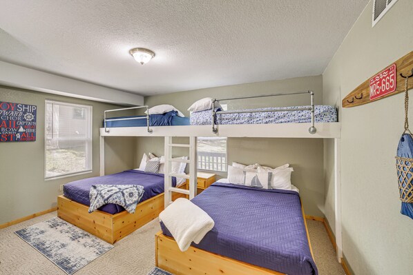 A dorm-style room with bunk beds, a wooden ladder, a window with blinds, and a wall sign. - Pool Access! Waterfront Home on Table Rock Lake (Kimberling City)