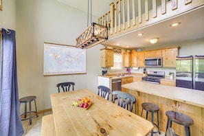 A kitchen with wooden cabinets, a microwave, a stove, and a refrigerator.