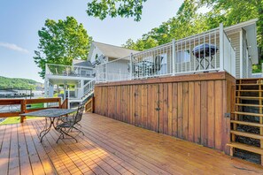 A wooden deck with a metal table and chairs, a wooden fence, and a grill on a raised platform. - Private Dock on Fishing Cove: Camdenton Getaway (Camdenton)
