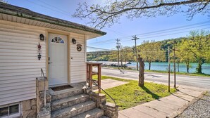 A house with a front porch, stone steps, and a view of a lake. - Rockaway Beach House w/ Fire Pit & River View! (Rockaway Beach)