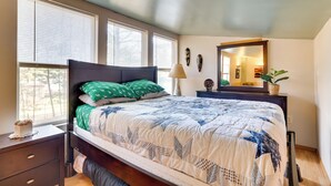 A bedroom with a bed, a nightstand, a dresser, a mirror, and a window with blinds. - Wisconsin Cabin w/ ATV Trails, Near Lake Arbutus! (Merrillan)