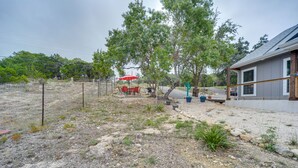 A fenced outdoor area with a red umbrella, a table and chairs, and a cactus decoration.