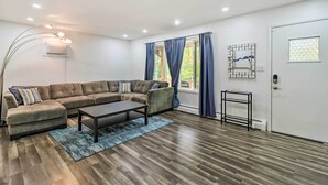 A modern living room with a sectional sofa, a coffee table, and a floor lamp.