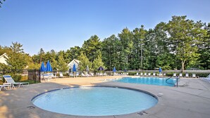 A swimming pool with lounge chairs and umbrellas, surrounded by trees and a fence. - Wells Cottage w/ Resort Amenities - 1 Mi to Beach! (Wells)