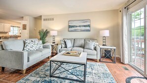 A living room with a grey sofa, a coffee table, and a painting on the wall.