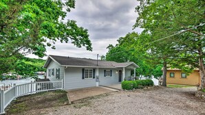 A single-story house with a front porch, a gravel driveway, and a small front yard.