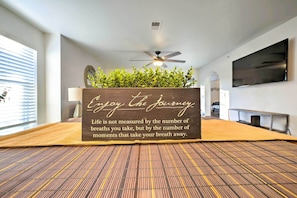A room with a bed, a ceiling fan, a television, and a motivational sign. - Near Branson Landing / Sister Condo Very Close By! (Branson)