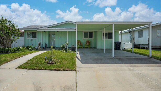A single-story house with a covered porch and a small front yard. - Pelican Cove by Miss Kitty’s (Rockport)