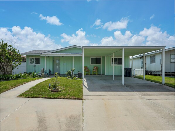 A single-story house with a covered porch and a small front yard. - Pelican Cove by Miss Kitty’s (Rockport)