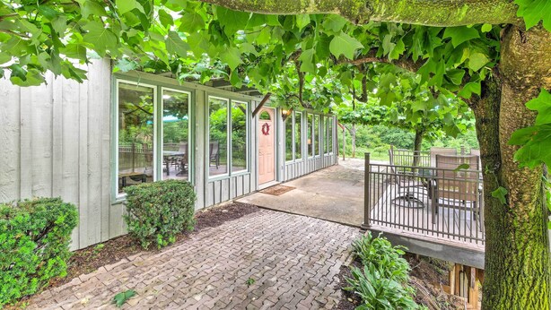 A covered outdoor seating area with a brick pathway leading to a wooden deck. - 'mimis Place' ~ Ohio Countryside Duplex w/ Deck (Dalton)
