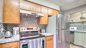 A kitchen with wooden cabinets, a stainless steel refrigerator, a microwave, a stove, and a coffee maker. - 'mimis Place' ~ Ohio Countryside Duplex w/ Deck (Dalton)