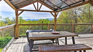A wooden deck with a picnic table and benches, overlooking a forested area with mountains in the distance. - Amenity-packed Nebo Oasis w/ Deck & Mtn Views (Nebo)