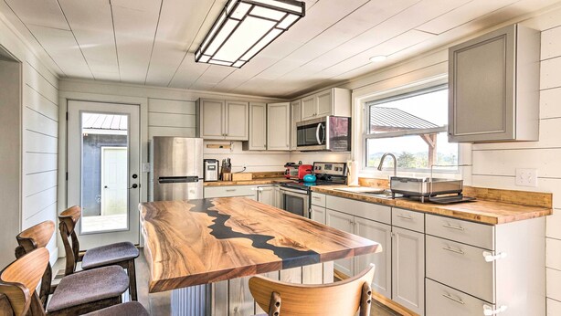 A kitchen with a central island, wooden chairs, and a view through a window. - Amenity-packed Nebo Oasis w/ Deck & Mtn Views (Nebo)