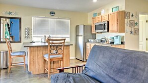 A compact kitchen with wooden cabinets, a stainless steel refrigerator, and a built-in microwave. - Albuquerque Studio With Shared Pool & Fire Pit! (Albuquerque)