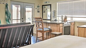 A compact kitchen with a wooden countertop, a sink, and a stove. There is a chair and a bench in the dining area. - Albuquerque Studio With Shared Pool & Fire Pit! (Albuquerque)