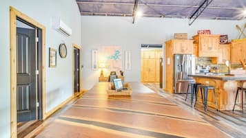 Eine geräumige Küche mit Holzausstattung, einem Edelstahlkühlschrank und einer Bar mit Hockern.