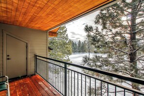 A wooden balcony with a metal railing overlooking a snowy landscape with trees. - Bend Condo w/ Deck, Resort-style Amenities & Views (Bend)
