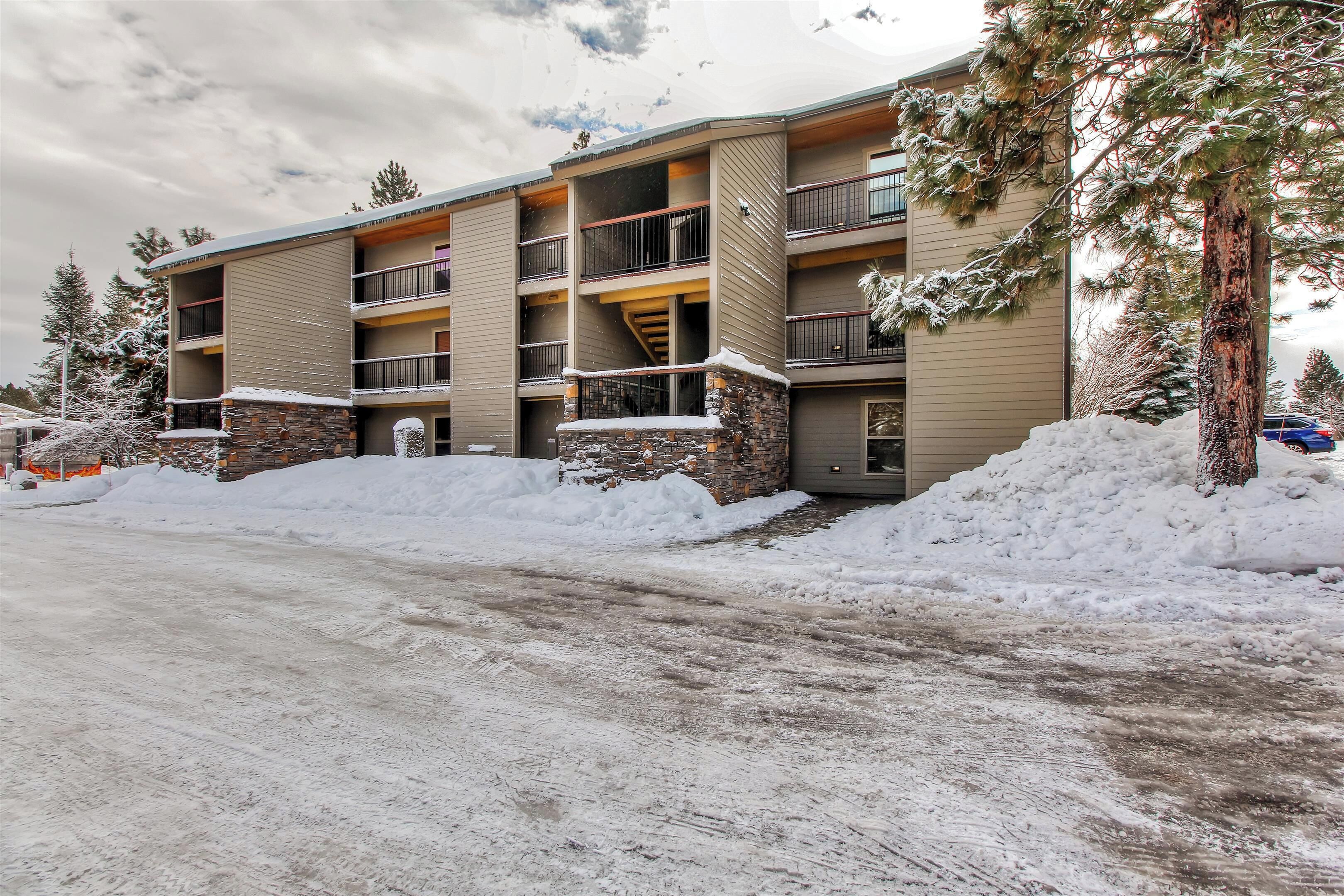 A multi-story hotel with balconies, stone accents, and snow-covered surroundings.