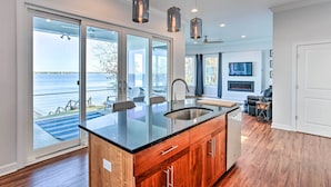 A modern kitchen with a large island, a built-in dishwasher, and a view of the outdoors. - Beautiful Waterfront Getaway w/ Dock! (Abbeville)