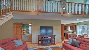A spacious living room with a fireplace, a large TV, and a cozy seating area. - Auburn Vacation Rental Home Near Owasco Lake! (Auburn)