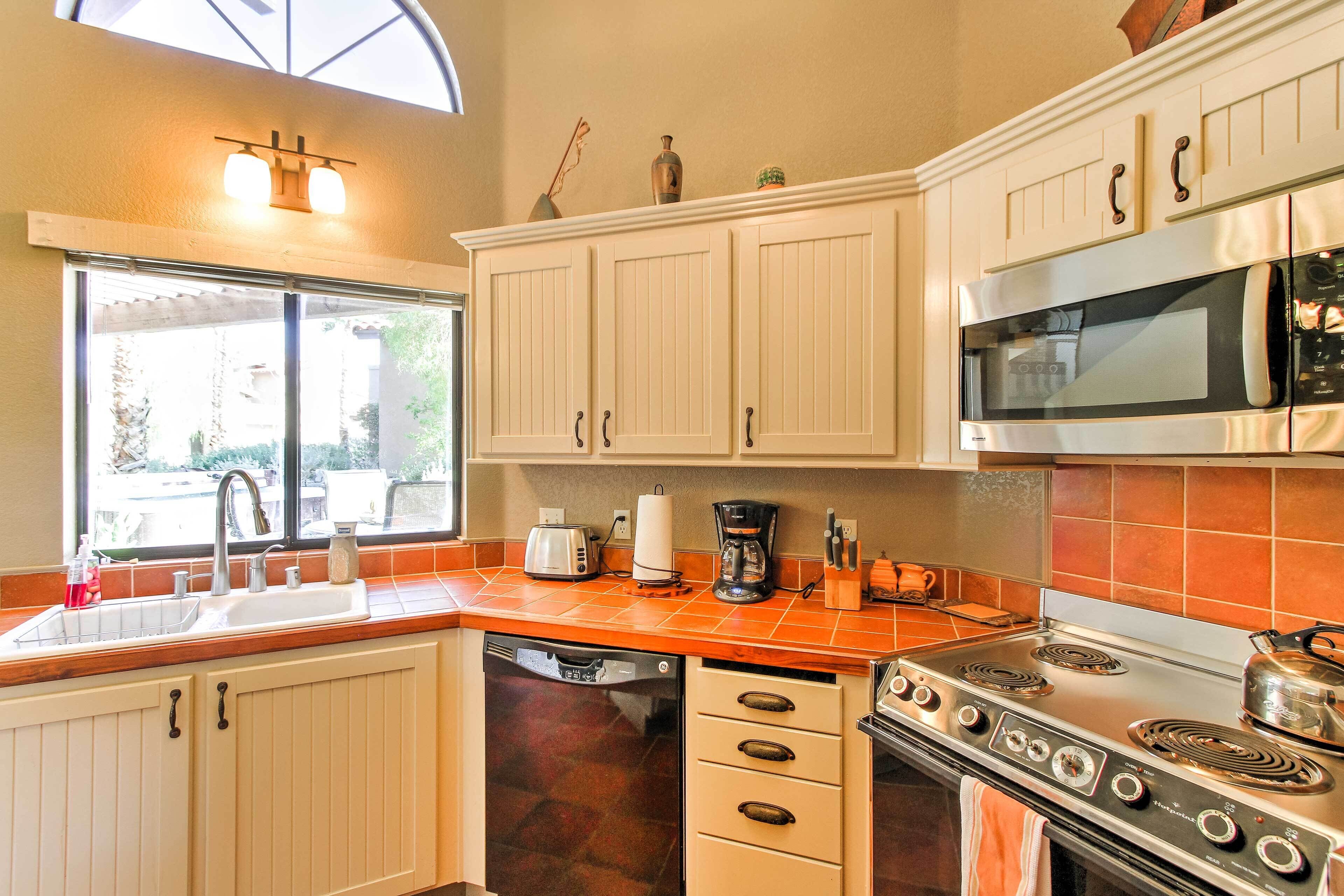 A kitchen with white cabinets, a stainless steel stove, a microwave, and a dishwasher.
