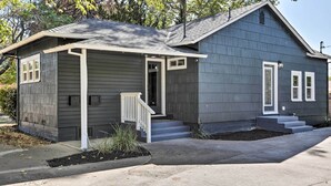 A two-story house with a front porch, a small attached garage, and a well-maintained lawn.