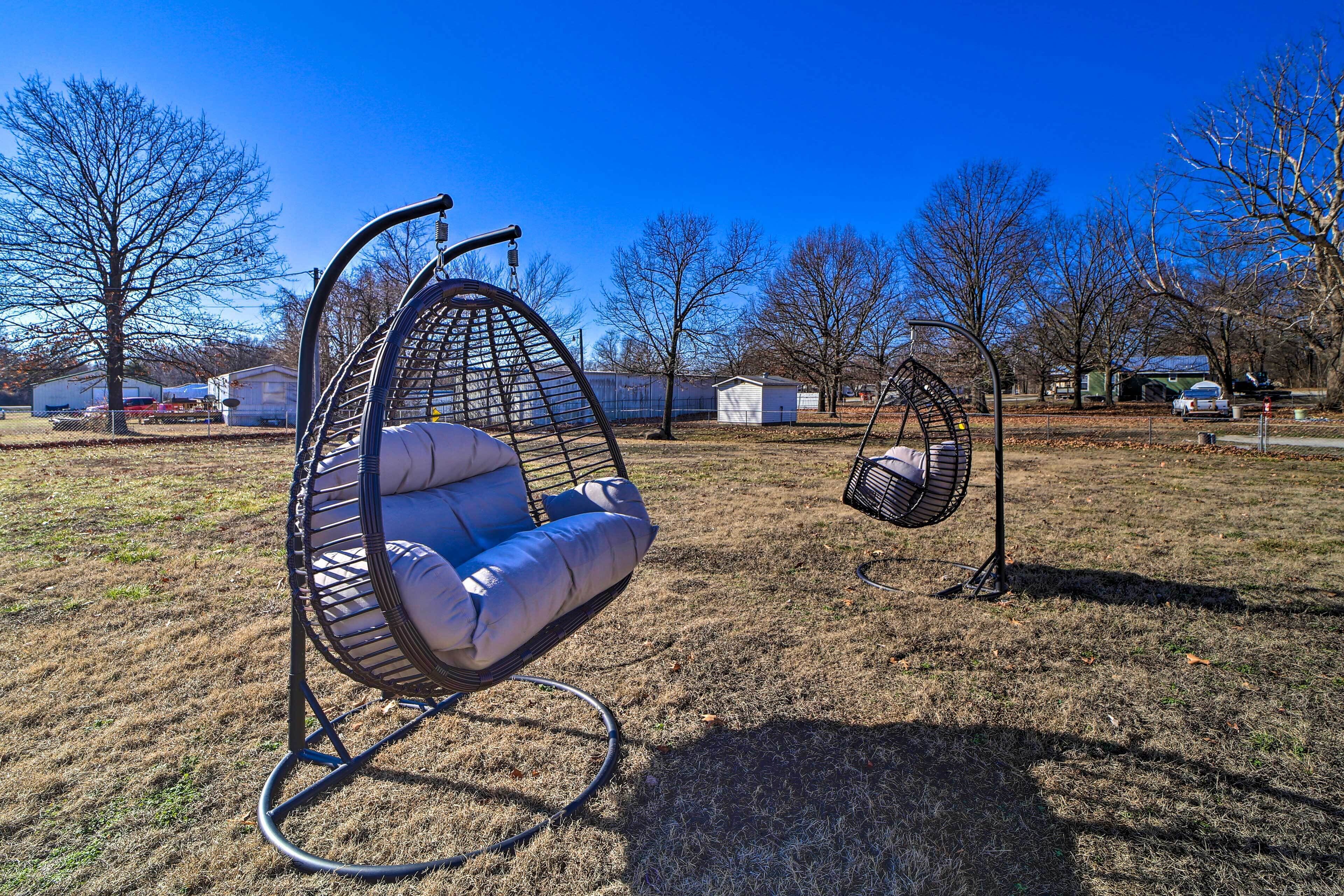 A hanging chair in a park with a clear sky.