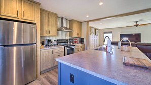 A modern kitchen with wooden cabinets, stainless steel appliances, and a large island. - Close to Marinas: Bernice Home w/ Large Yard (Afton)