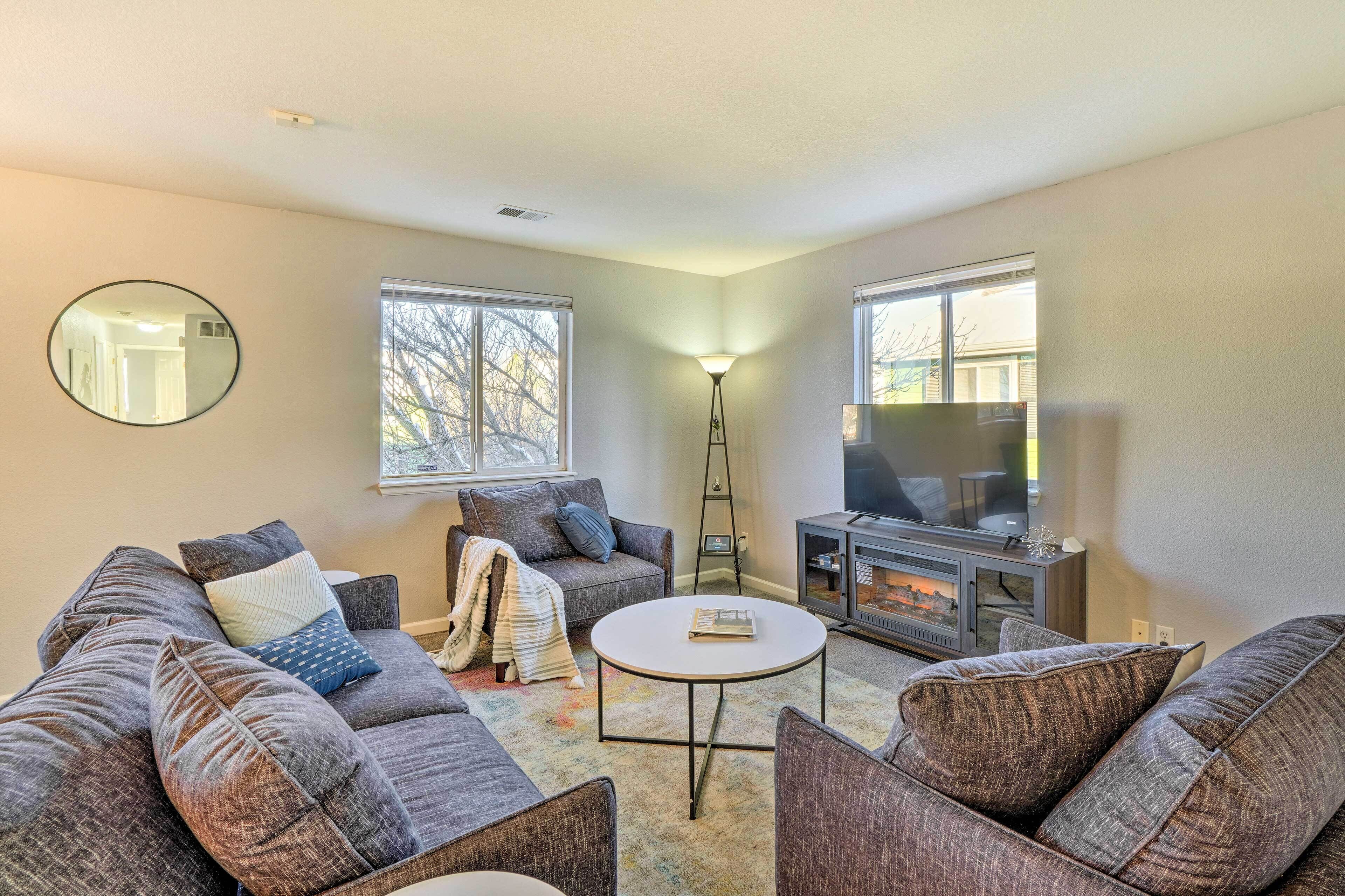 A living room with a sofa set, a coffee table, a fireplace, and a television.