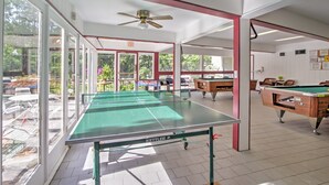 A spacious indoor area with a ping pong table, pool tables, and a ceiling fan. - Mtn-view Cabin w/ Private Hot Tub in Gatlinburg! (Gatlinburg)