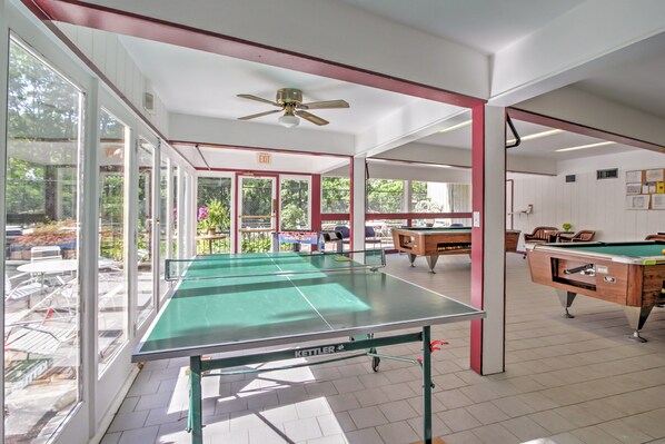 A spacious indoor area with a ping pong table, pool tables, and a ceiling fan. - Mtn-view Cabin w/ Private Hot Tub in Gatlinburg! (Gatlinburg)