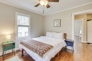 A bedroom with a bed, a nightstand, a ceiling fan, a window with blinds, and a door leading to another room. - Walk to Ruffner Mountain: Family Home w/ Yard (Birmingham)