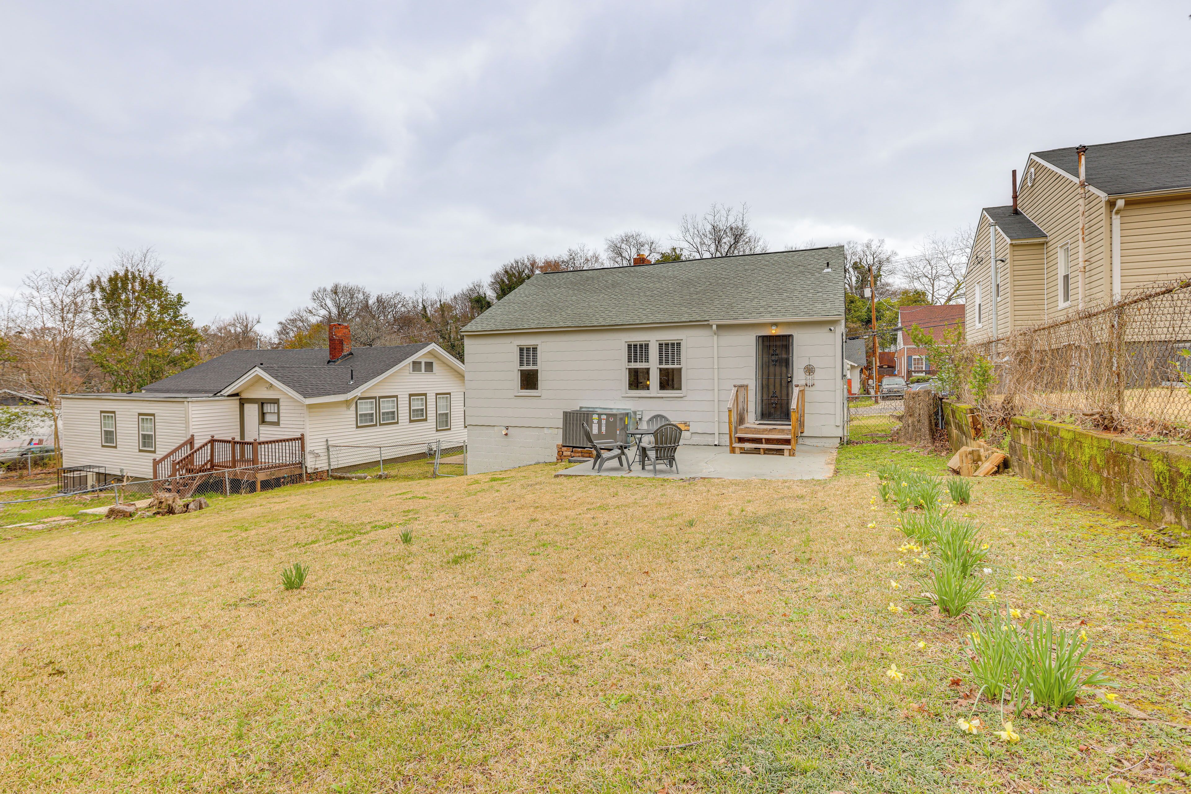A residential property with a fenced yard, a small patio with outdoor furniture, and a detached garage.