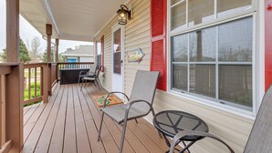 A covered porch with wooden flooring, a table, chairs, and a lantern. - Charming Biloxi Vacation Rental Near Beach! (Biloxi)